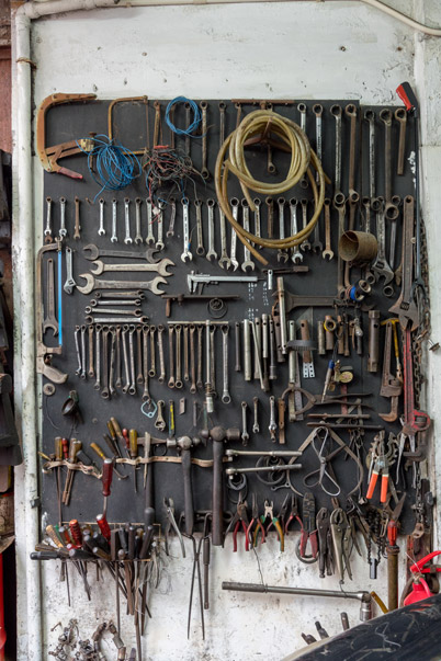 牆上掛著一大堆維修工具，例如「呤士」、「卜士」，以及用於修理車輛不同位置的工具等。