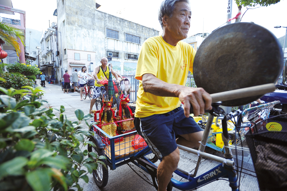 居民用單車載著候王像沿途打銅鑼。
