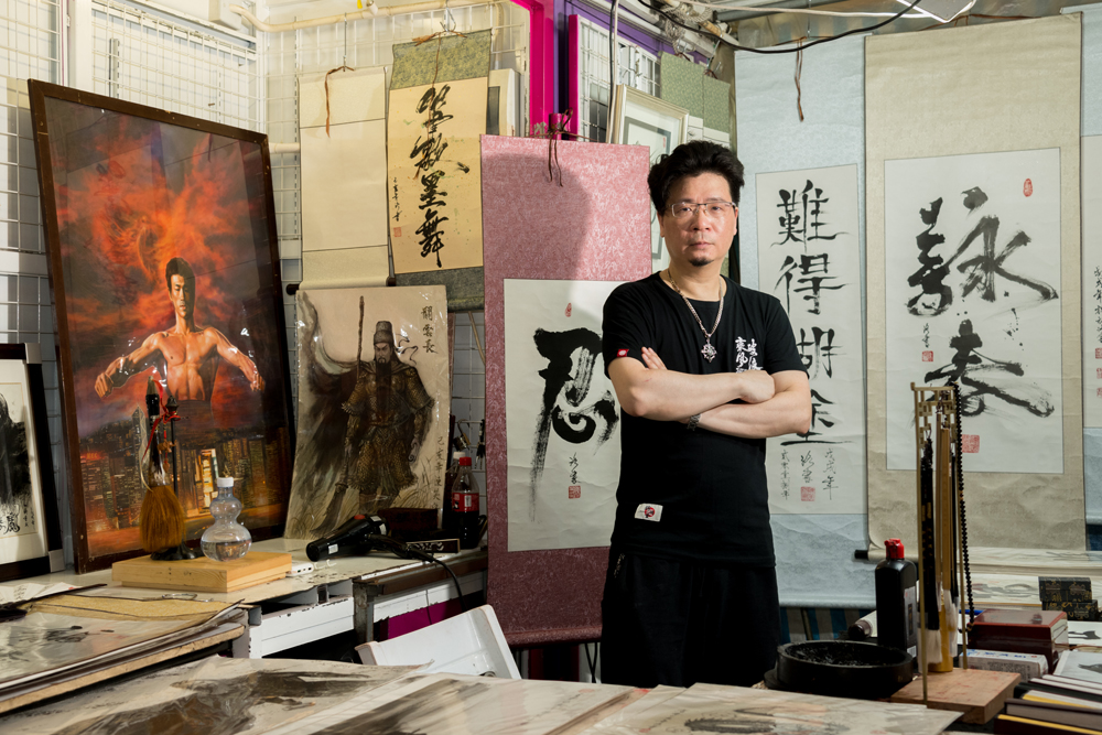 陳笑洛在廟街檔口專售自己的書法及水墨畫作品。