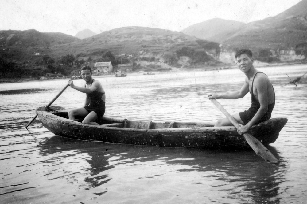 1938年。舢舨位於今三家村碼頭的酒灣。舢舨上兩位都是原居民，穿著最新款男仕泳衣。背景是今三家村油塘工業區及油塘商業中心。