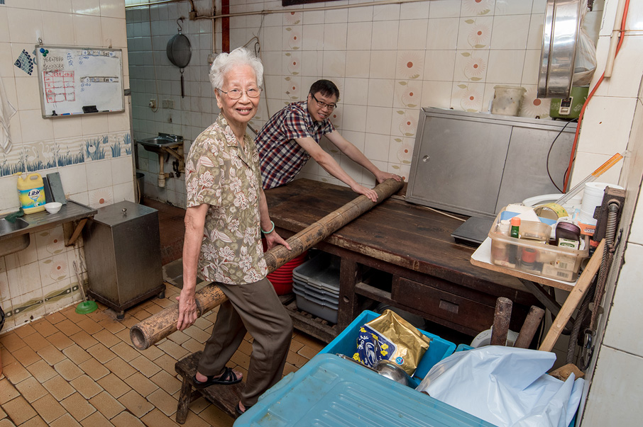 麵店第一代當家夫人陳老太與現時負責人陳仕傑，示範昔日師傅人手打麵的情 況，當年他們每天至少打出百擔麵。